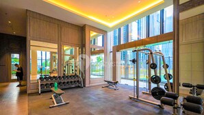 Une salle de sport équipée de matériel de musculation, d’haltères et de bancs.