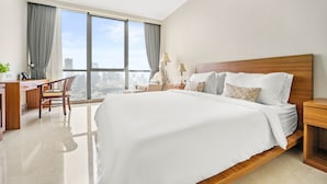 Une chambre d’hôtel moderne, dotée d’un grand lit, d’un bureau et d’une chaise.