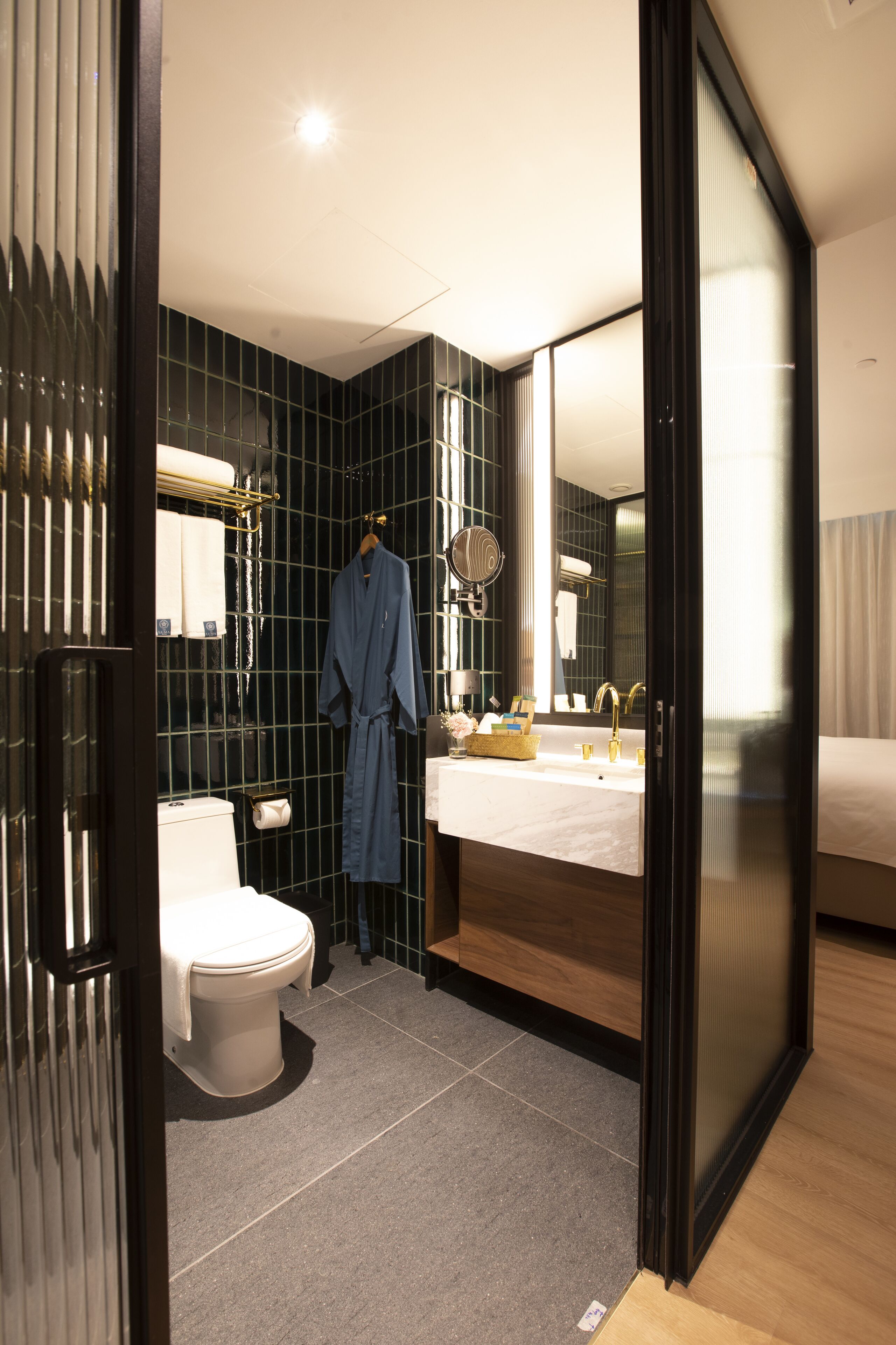 Un baño moderno con inodoro, lavamanos y espejo.