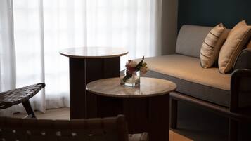 Un salon moderne avec une table ronde, un canapé avec des coussins et un fauteuil.