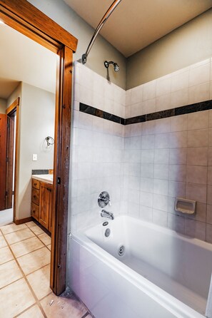 Une salle de bain avec une baignoire, une douche et des toilettes.