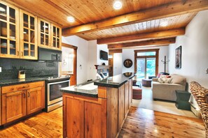 Une cuisine spacieuse avec des meubles en bois, un îlot central et une grande fenêtre.