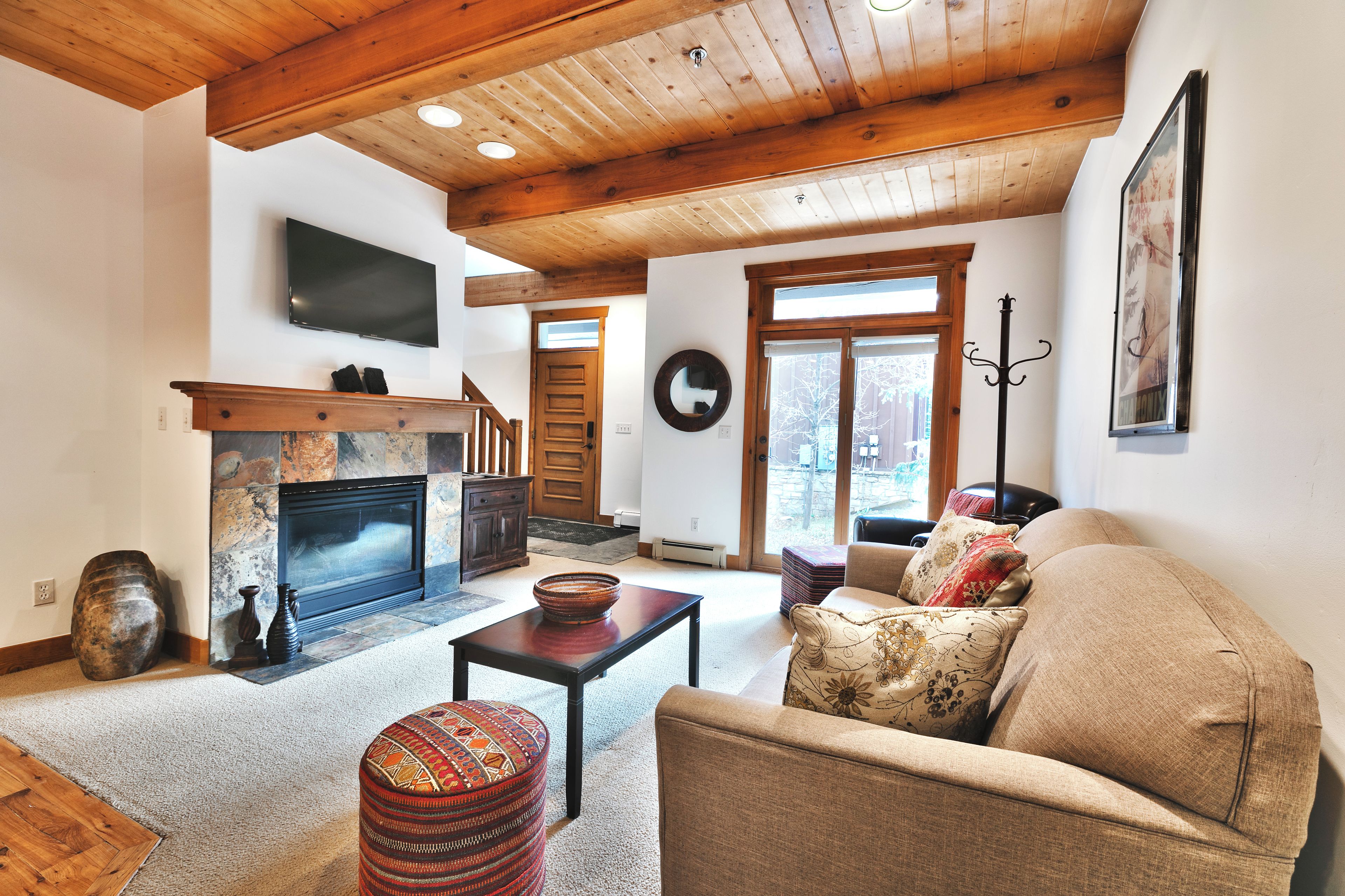 A living room with a fireplace, a sofa, a coffee table, and a television.