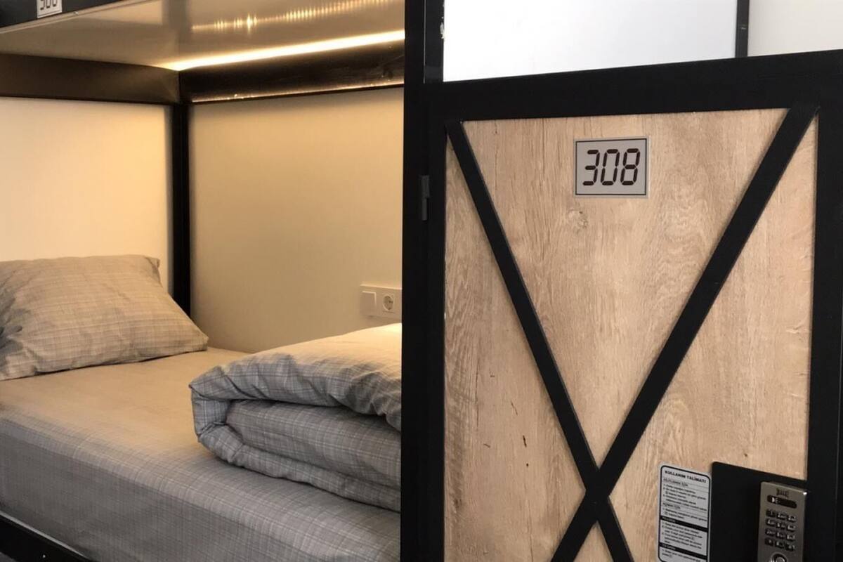 A bunk bed with a headboard labeled "308" and a curtain on the left side.
