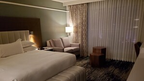 Ein Hotelzimmer mit einem großen Bett, einer Couch, einem kleinen Tisch und einem Sessel.
