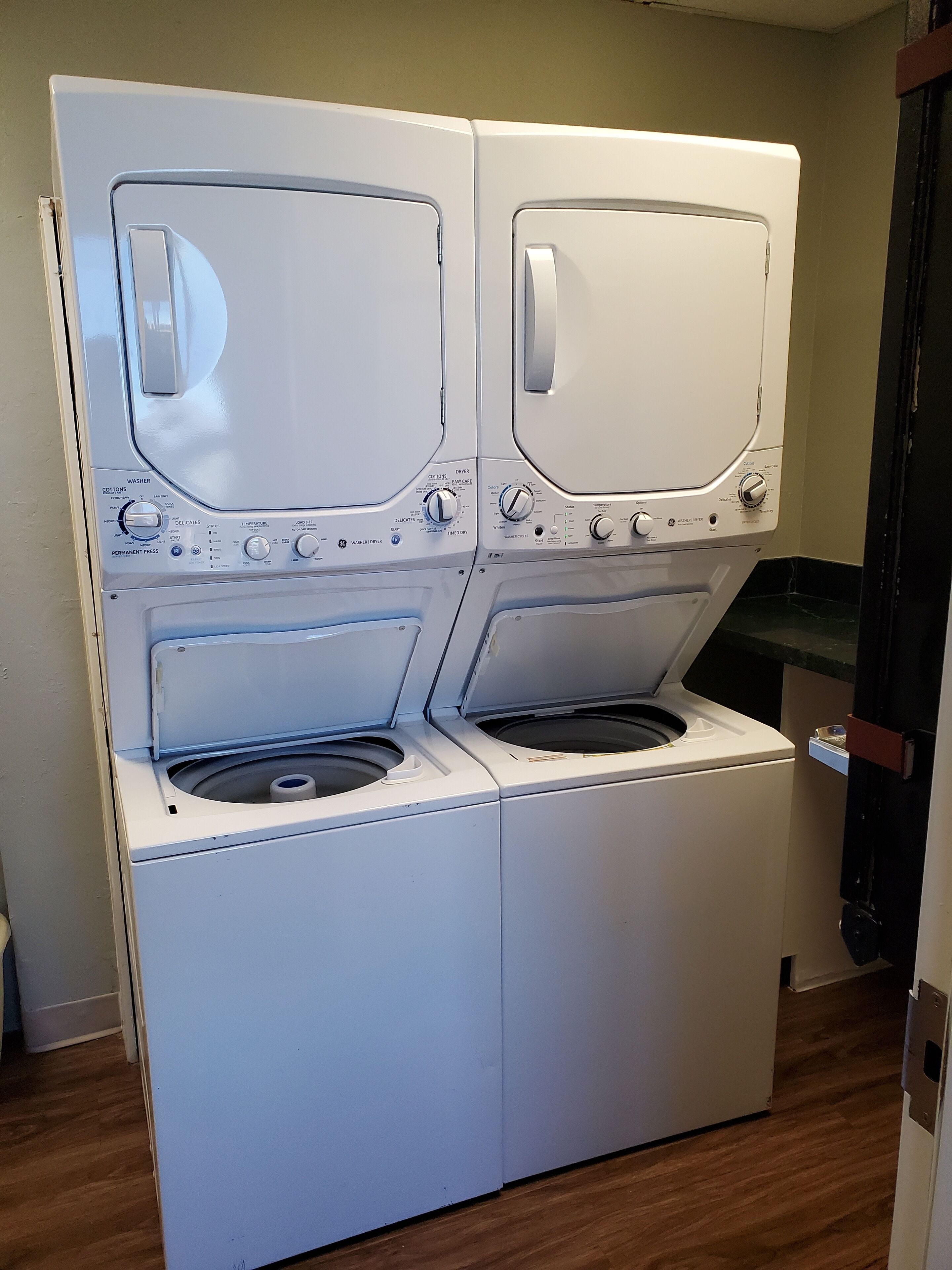 A front-loading washer and dryer unit with control panels and a front-loading machine.