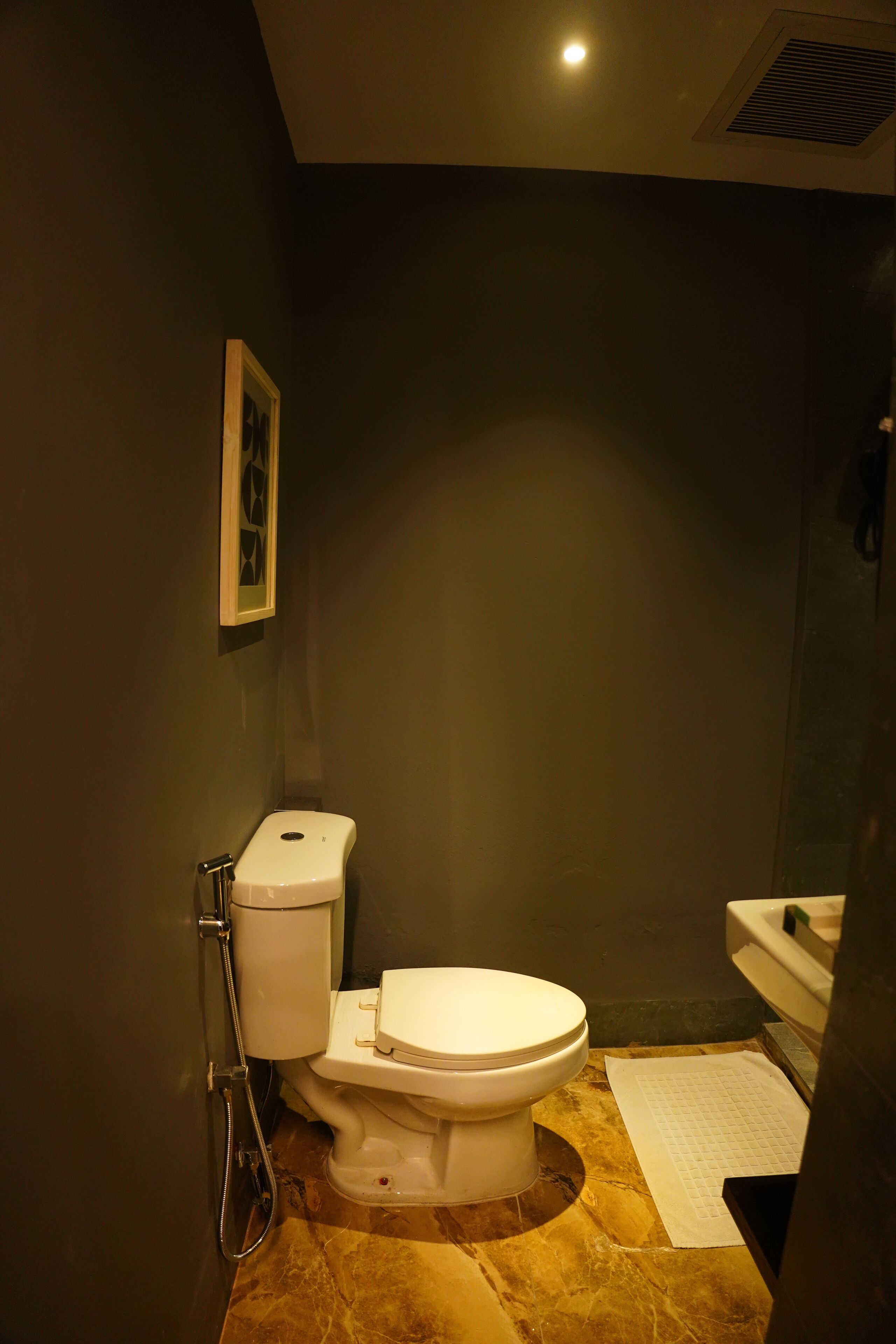A small bathroom with a toilet, a shower, and a sink.