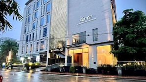 A modern hotel with a prominent sign reading "EMPYREAN" and a large vertical sign with the word "VIRGIN" on the facade. - Empyrean Hotel (Dhaka)