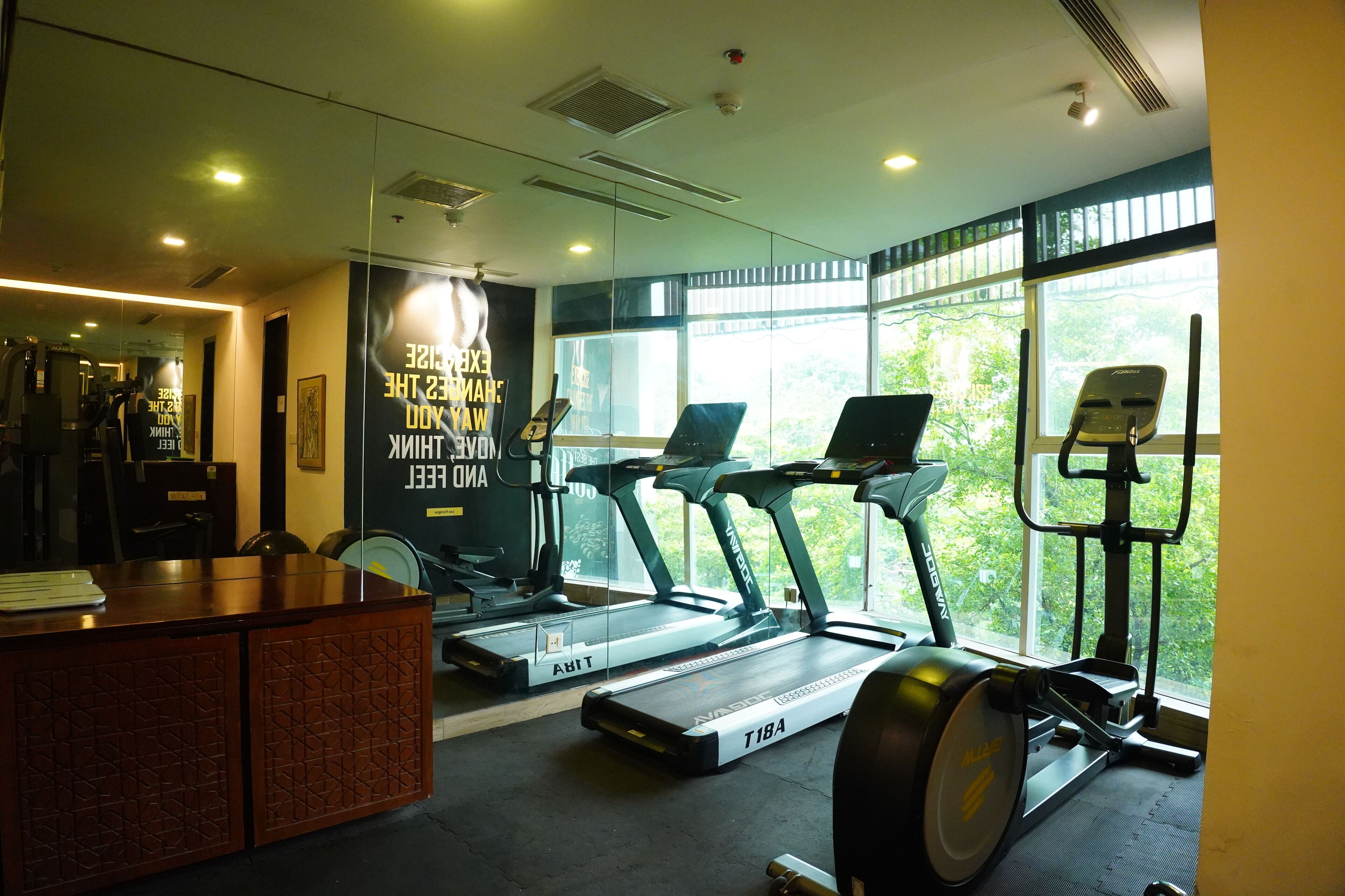 A gym with treadmills, a stationary bike, and a reception desk.