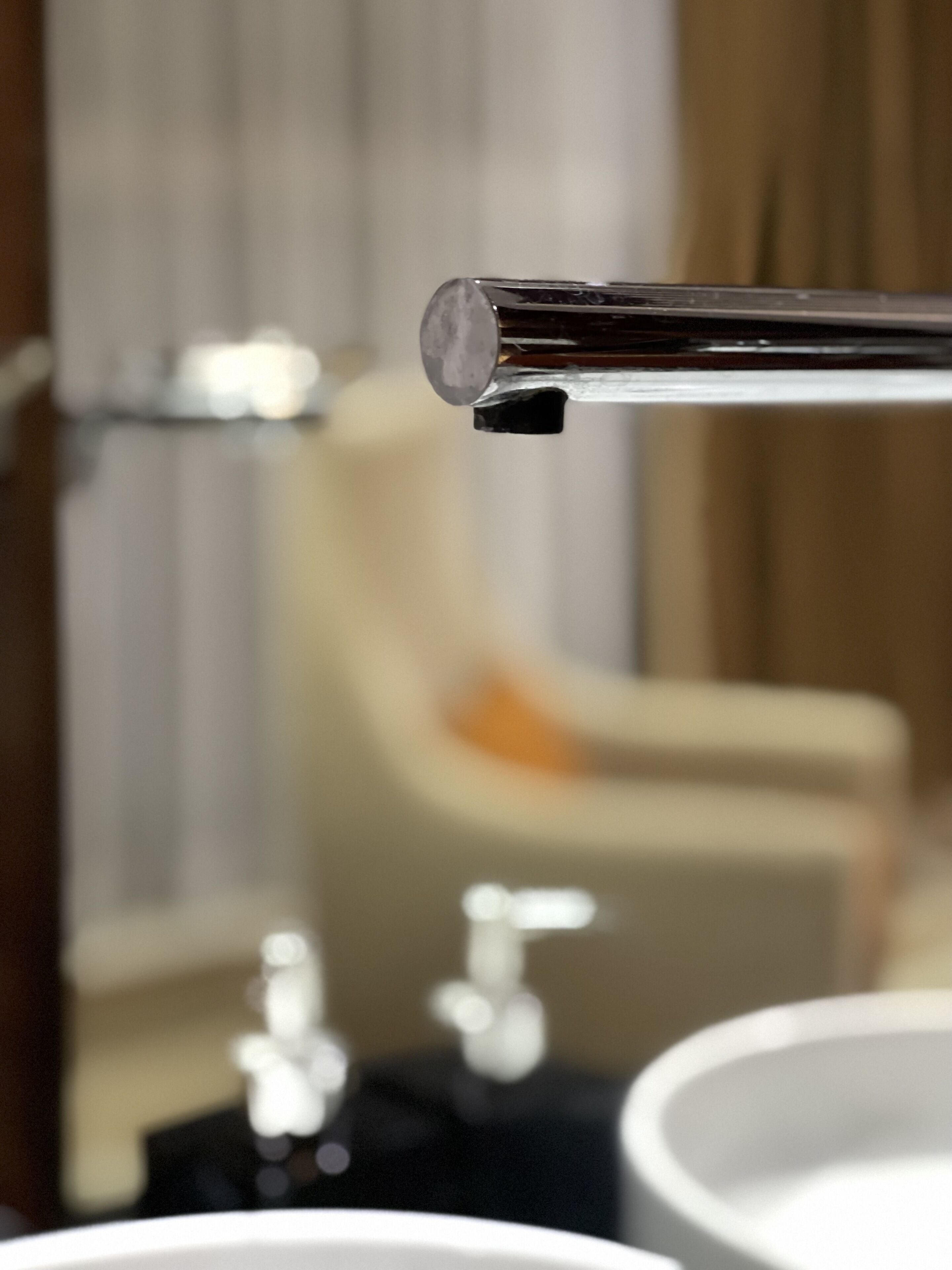 A bathroom with a mirror, a sink, and a towel rack.