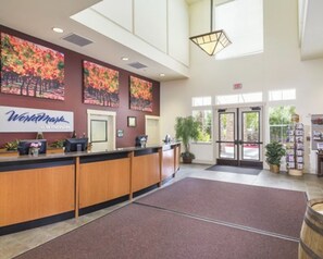 Welcome to WorldMark Hotel, where guests can check in at the reception desk amidst lush greenery and natural light.