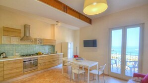 Una cocina moderna con comedor, ventanas amplias y un balcón con vistas.