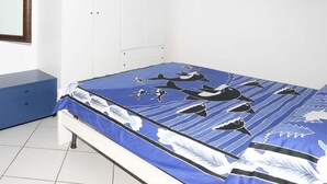 Un dormitorio con cama, armario, cómoda y un cuadro en la pared.