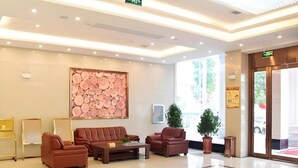 A modern lobby with a seating area, a large decorative wall, and a glass entrance. - Greentree Inn Fuyang Development Zone Weisan Road Express Hotel (Fuyang)
