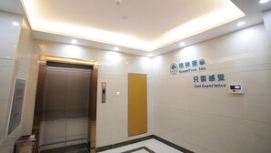 A modern elevator with a digital display, a wall-mounted sign with text, and a patterned floor. - Greentree Inn Fuyang Development Zone Weisan Road Express Hotel (Fuyang)