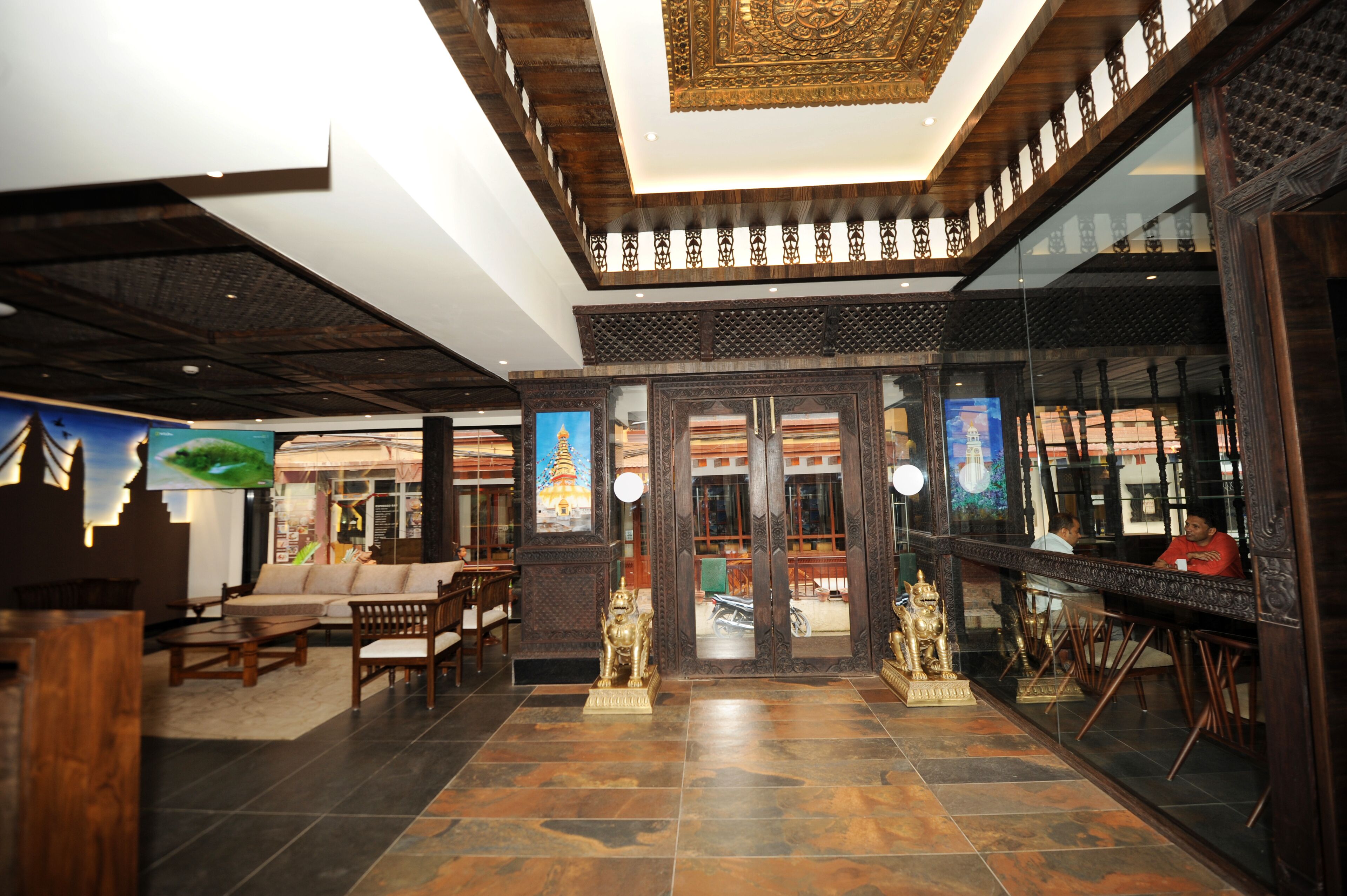 A lobby with a reception desk, seating area, and decorative statues.