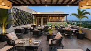 An outdoor patio with seating, a bar area, and a view of the cityscape. - Regenta Place Amritsar (Amritsar)