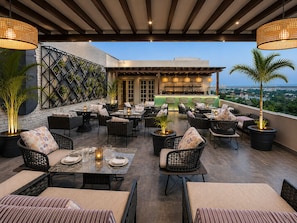 An outdoor patio with seating, a bar area, and a view of the cityscape. - Regenta Place Amritsar (Amritsar)