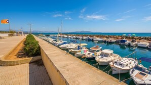 A marina with boats docked along a waterfront promenade.