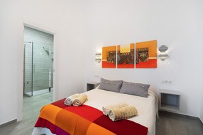 Une chambre d’hôtel avec un lit, une douche et une œuvre d’art accrochée au mur.