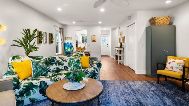 Un salon moderne avec un canapé, une table basse et un ventilateur de plafond.