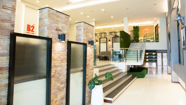 Um interior moderno com uma parede de pedra, uma escadaria e uma placa com o texto 'B2'.