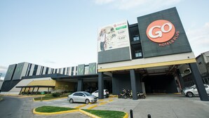 A modern building with a prominent Go Hotels Plus sign.