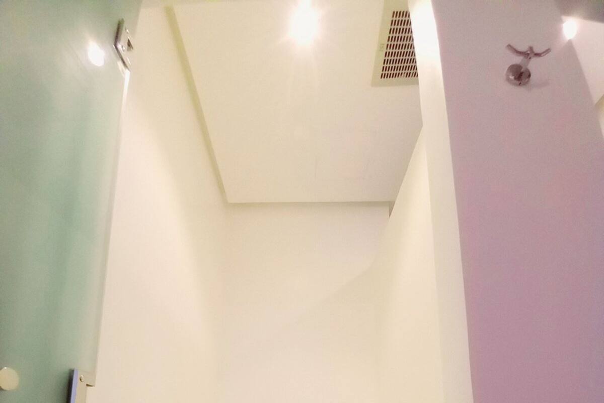 Un baño pequeño y funcional con inodoro, ducha y secador de manos.