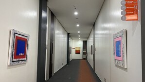 A hallway with directional signs for function rooms, restrooms, and an elevator.
