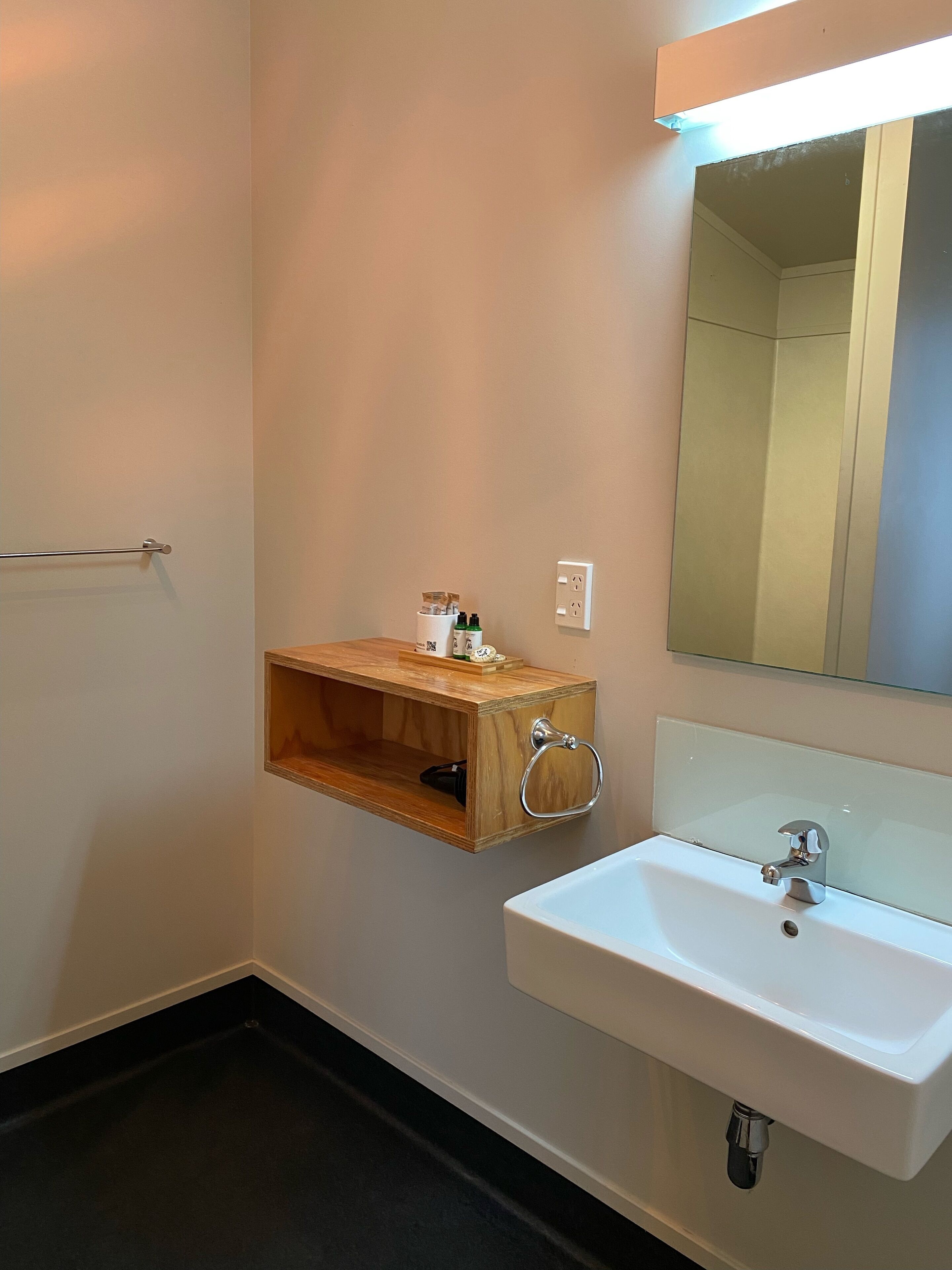 Un baño con un lavabo blanco, un armario de medicinas de madera y un espejo.