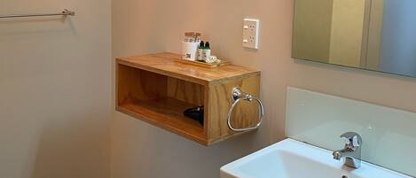 Un baño con un lavabo blanco, un armario de medicinas de madera y un espejo.