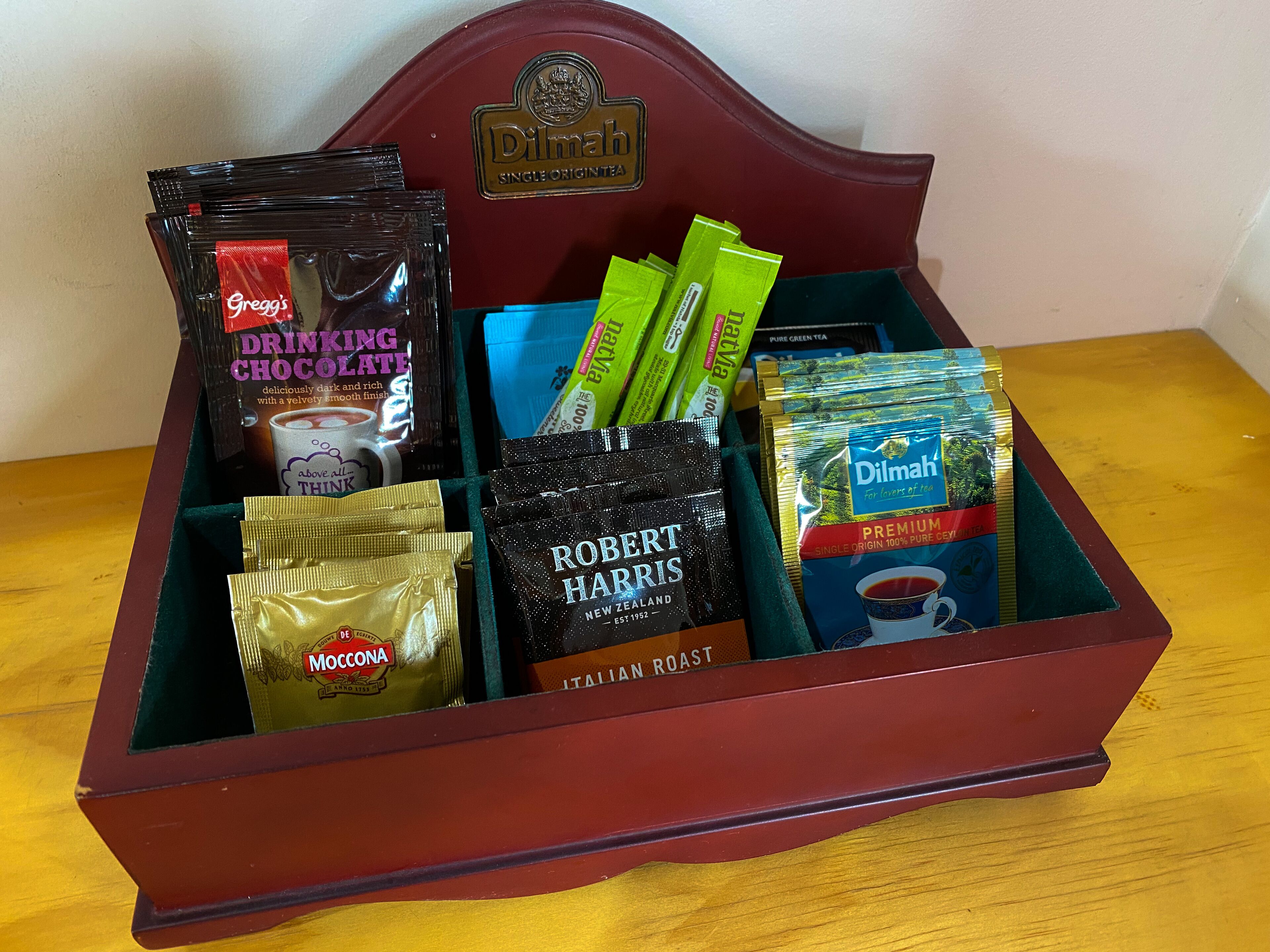 A wooden box containing various tea and chocolate products.