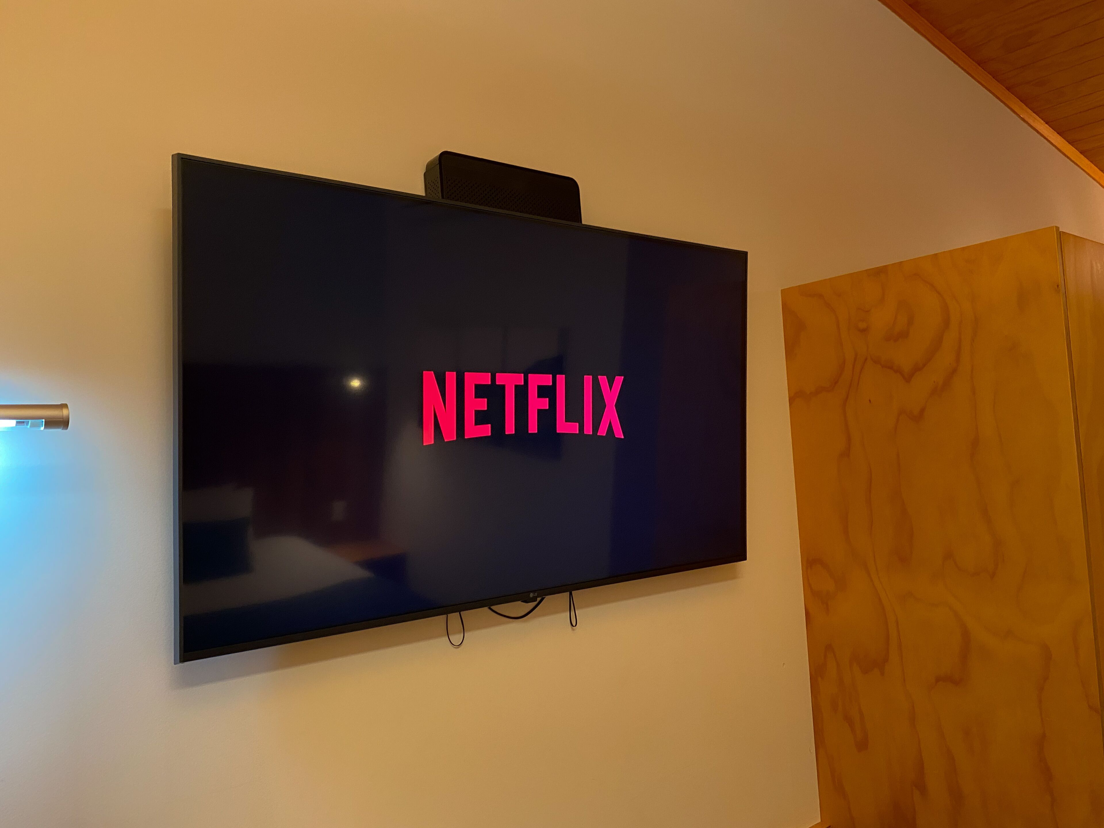 A flat-screen TV mounted on a wall with the word "NETFLIX" in red letters.