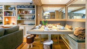 Ein gemütliches Interieur mit einem Holzesstisch, Bücherregalen und einer bequemen Sitzecke.