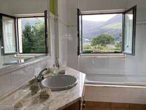 A bathroom with a large window, a sink, and a bathtub. - WATER FRONT SECRET GARDEN (ORTIGUEIRA)