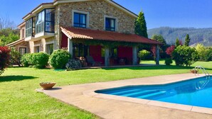 A two-story stone house with a red roof, a swimming pool, and a well-maintained garden. - WATER FRONT SECRET GARDEN (ORTIGUEIRA)