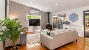 Un salon moderne avec un canapé, un téléviseur et une cheminée.