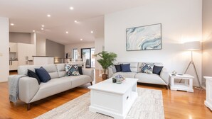 Un salon moderne avec deux canapés, une table basse et un lampadaire.