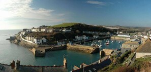 A coastal town with a fortified harbor, historic buildings, and a hilltop view. - Luxury Cottage with Parking, Minutes to Beach and Restaurants (Porthleven)