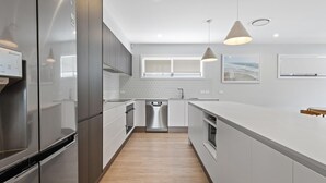 Een moderne keuken met roestvrijstalen apparatuur, een vaatwasser en een groot kookeiland.