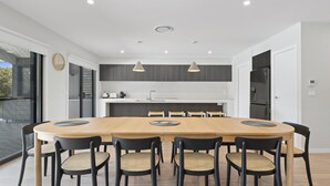 Una cocina moderna con una isla central, muebles oscuros e iluminación colgante.