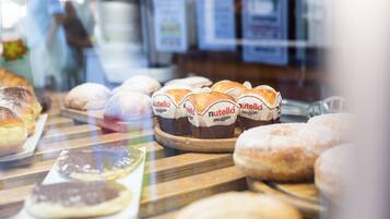 A bakery display with various pastries, including muffins and donuts, visible through a glass window.
