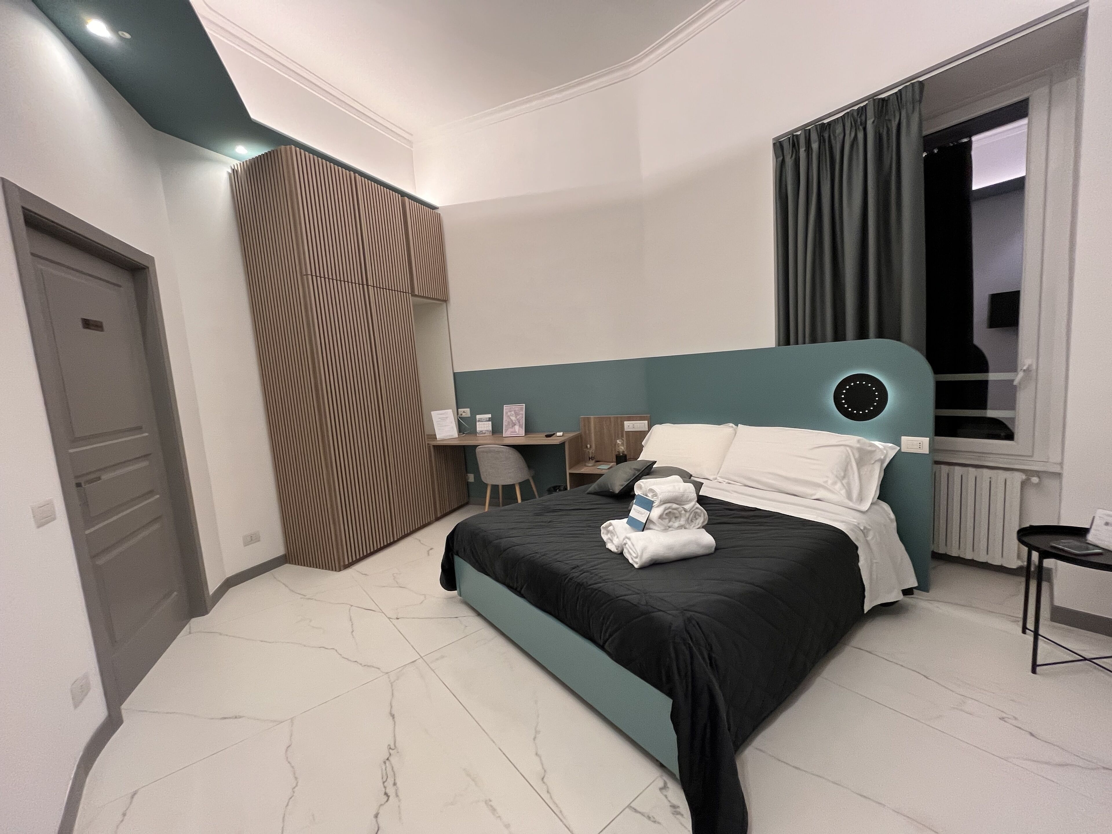 Una habitación de hotel moderna con cama, escritorio y ventana.