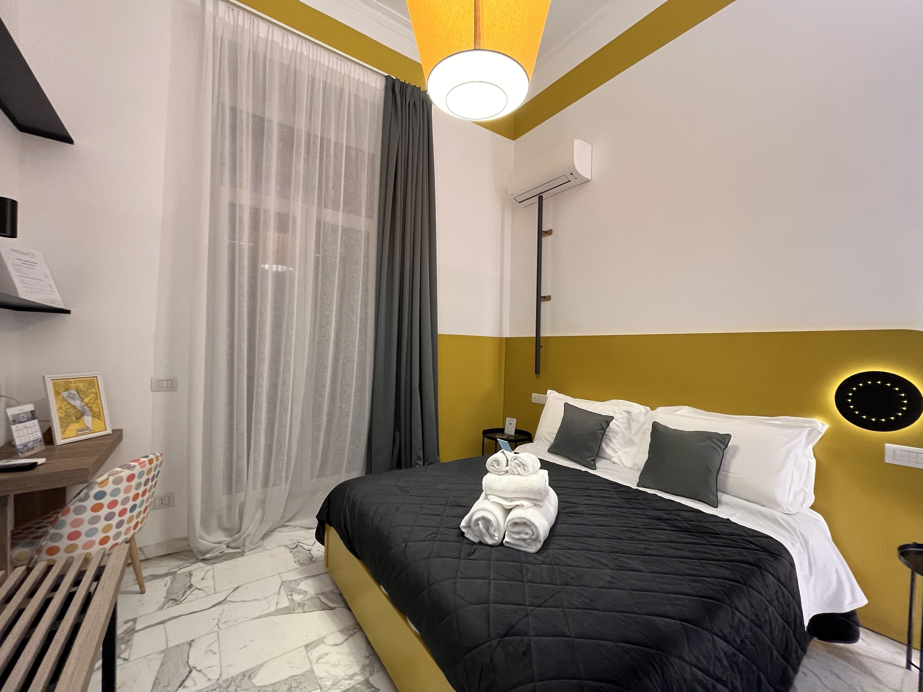 Una habitación de hotel moderna con una cama, un escritorio y una silla.