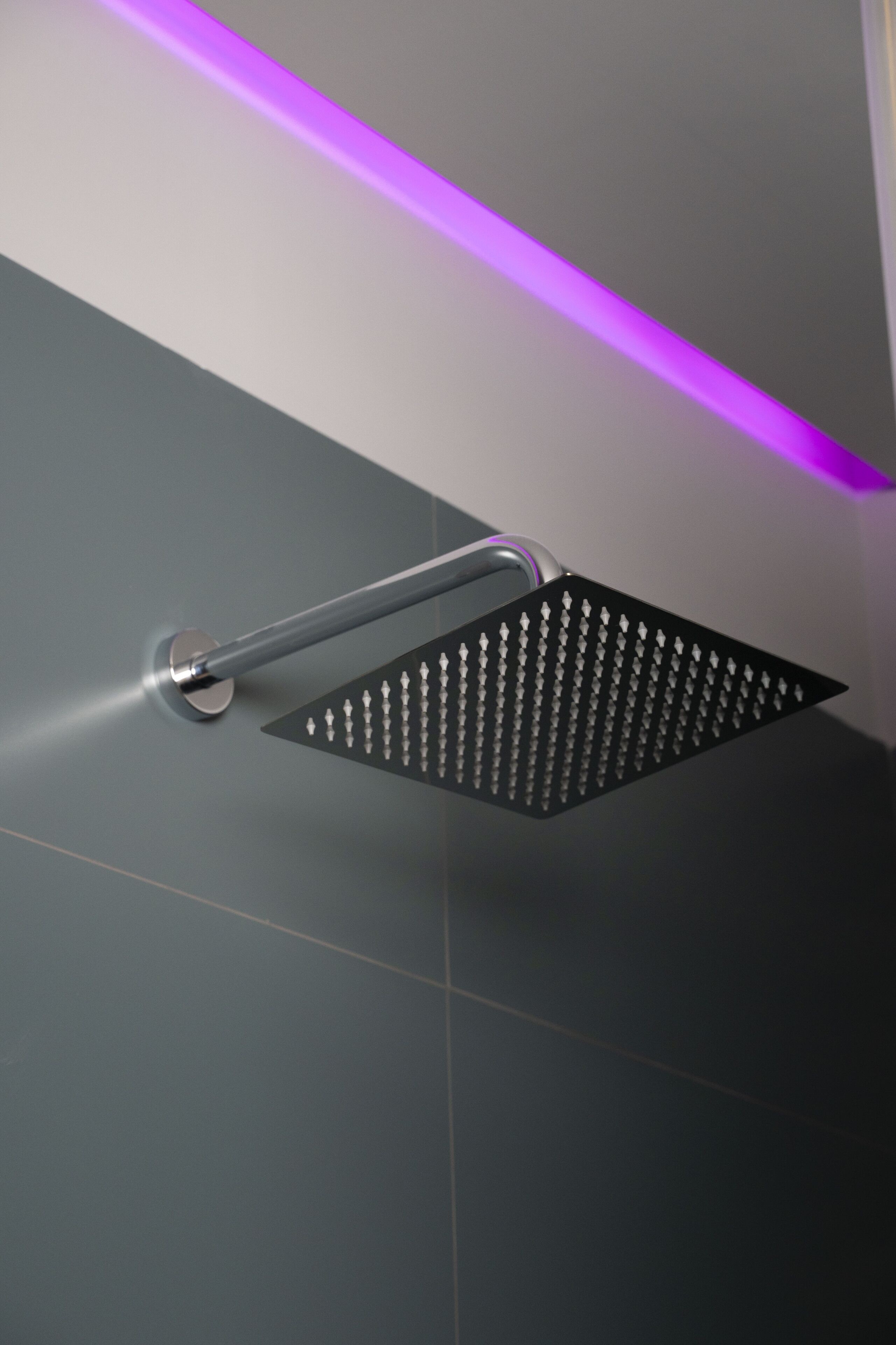 A modern shower with a square head and a metallic handle.