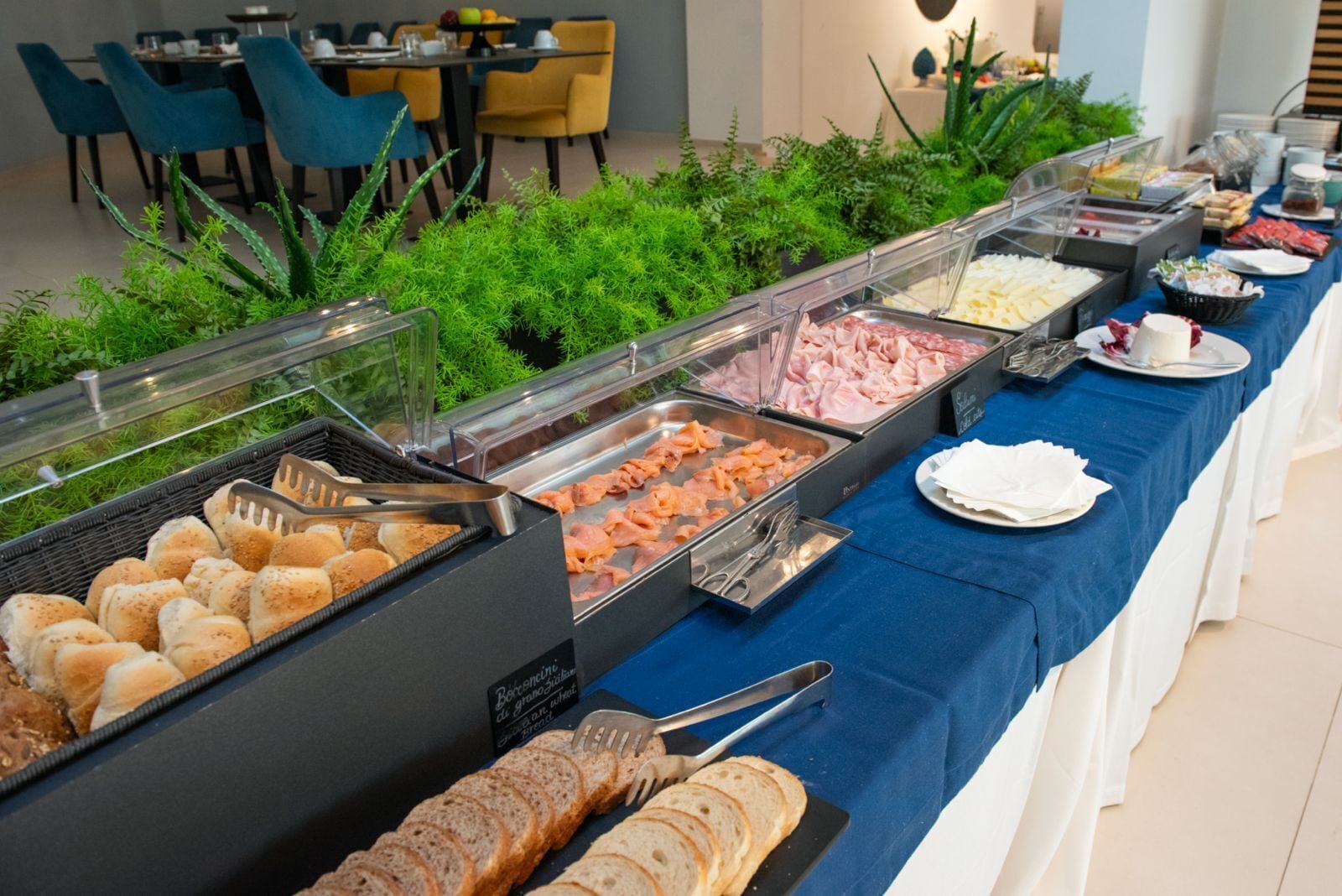 A buffet with various food options including bread, meats, and fruits.