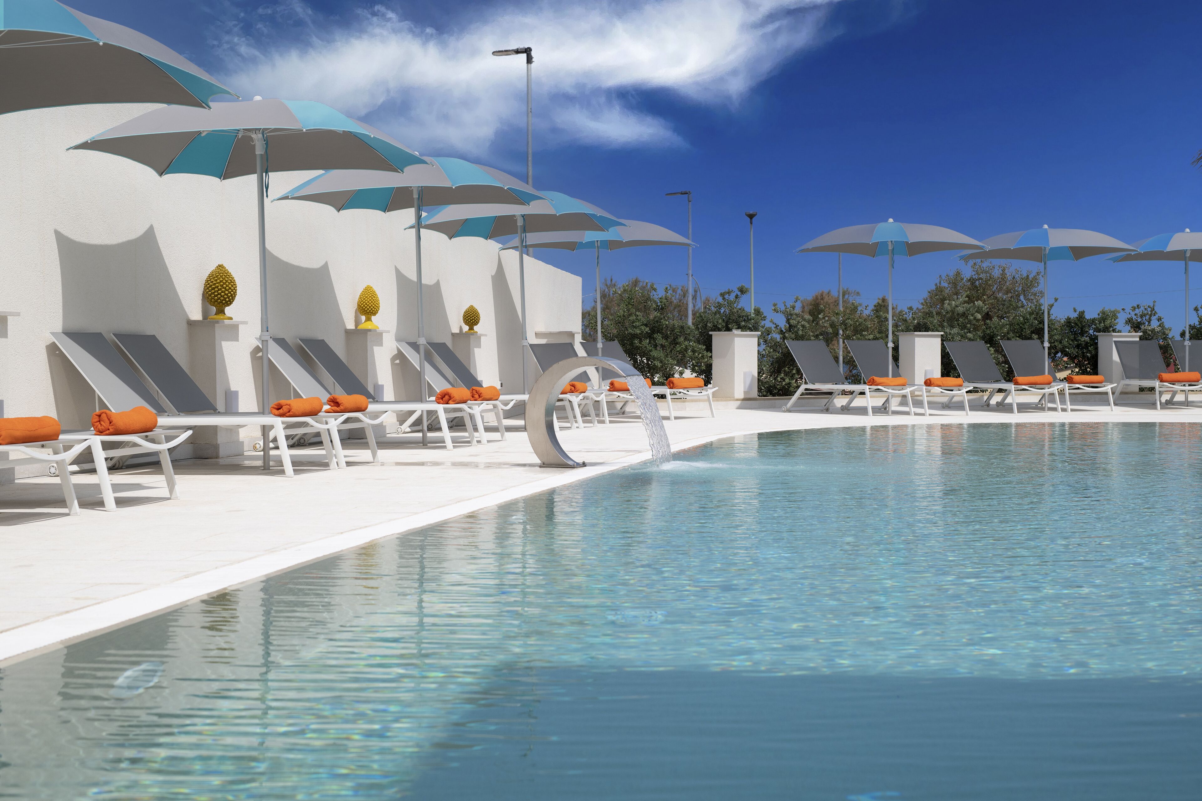 A poolside area with sun loungers and umbrellas.