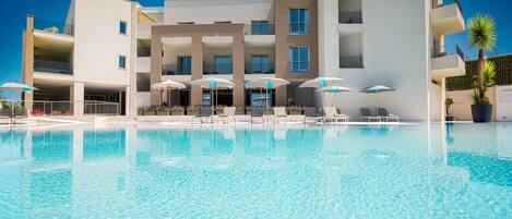 Piscine extérieure, parasols, chaises longues