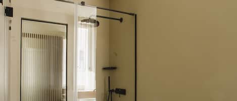 Un baño moderno con cabina de ducha de vidrio, inodoro blanco y bidé.