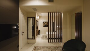 A hotel room with a bed, a chair, a TV, a wardrobe, and a mirror. - Palazzo della Fontana (Matera)